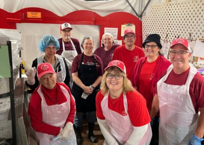 People dressed in red aprons and hats, appearing to be part of a festive or organized gathering.