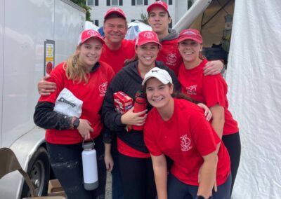 A group of people wearing red shirts and hats, standing together.