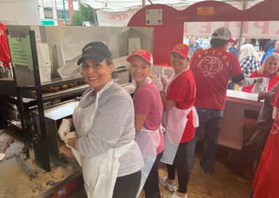 A diverse group of people standing around a food truck, chatting and enjoying a variety of delicious street food.